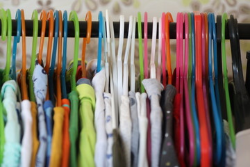 a lot of colourful hangers with bright clothes