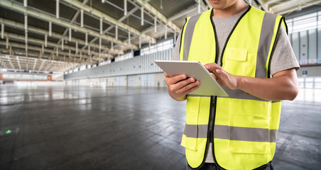 worker hand holding pad for check order pick time in empty warehouse