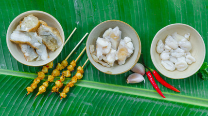 Fototapeta na wymiar Phan Thiet street foods made from squid: grilled squid cake, steamed squid's egg and fried squid's mouth - Rang muc nuong