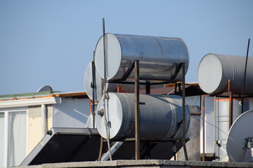 Steel barrels of boilers with water on the roof of a building to heat water
