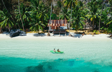Couple enjoying time kayaking in front of the beach in Coron. Concept about summer,...