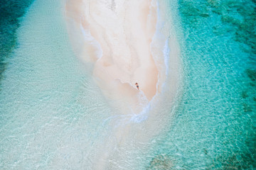 Naked island view from the sky. Man relaxing taking sunbath on the beach.shot taken with drone...