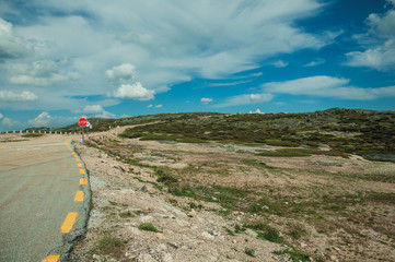 Roadway passing through rocky landscape and fields