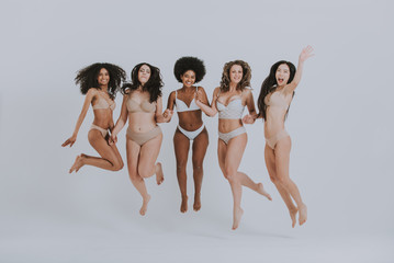 Group of women with different body and ethnicity posing together to show the woman power and...