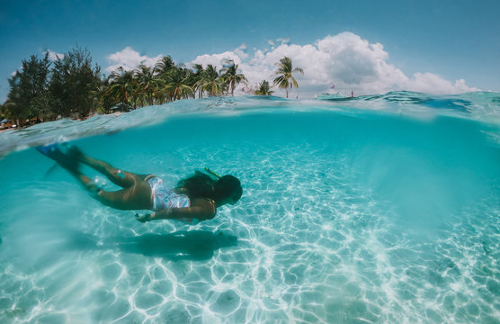 Beautiful Woman Swimming Underwater In A Tropical Sea Full Of Corals. Under Water Shot With Action Camera. Concept About Wanderlust Travels