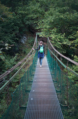 Fototapeta na wymiar Back of one young woman on a metal bridge above Hornad river