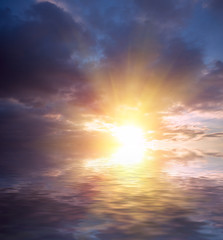 The last rays of the sun dramatic sunset of all colors of the rainbow on the background of the waves.