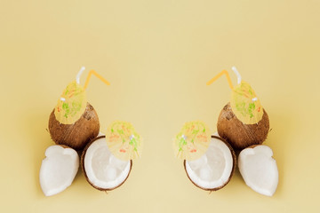 Fresh Coconut cocktail with a straws on yellow background, copy space