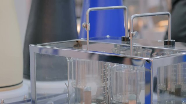 Pharmaceutical testing equipment - automatic tablet disintegration and dissolution apparatus with two basket at pharmacy factory or exhibition. Pharma industry, medicine and science concept