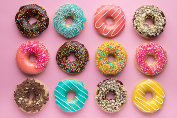 Colorful sweet background. Delicious glazed donuts on pink background.  - Powered by Adobe