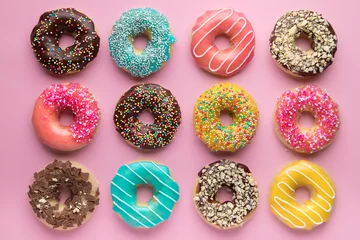 Keuken spatwand met foto Colorful sweet background. Delicious glazed donuts on pink background.  © fedorovacz