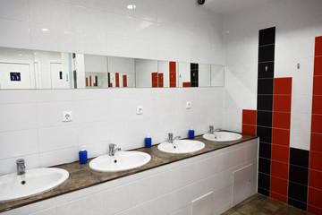 Empty restroom public men bathroom interior with washing hand sinks. Mirror with hand basin in clean toilet.