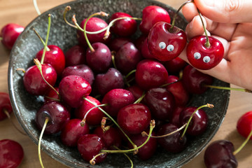 fresh cherry in the ceramic bowl on the table for summer fruits concept.