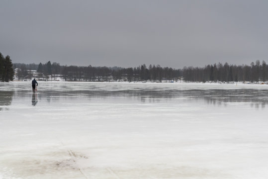 Man sledging on a frozen lake in monotone conditions