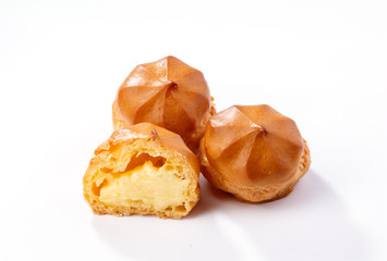 Profiterole or eclair, homemade sweets, close-up, isolated on white background.