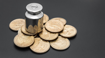 Weight with coins on black. Business concept. Tax load.