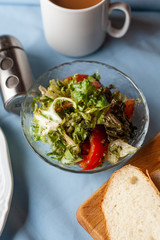 Green vegetable starter of a three course set menu: mixed salad leaves with tomatoes and olive oil, served on bright tablecloth