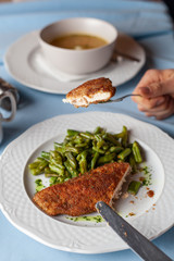 Woman is having a deep fried chicken schnitzel with crunchy crust chicken noodle soup for a nutritious lunch