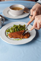 Woman is having a deep fried chicken schnitzel with crunchy crust chicken noodle soup for a...
