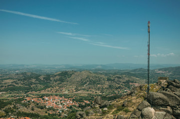 Obraz premium Antenna on hilltop covered by rocks and bushes in Monsanto