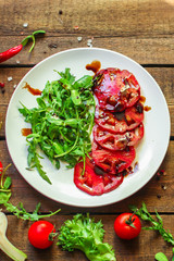 salad with tomatoes, arugula, balsamic sauce (fresh vegetables and salad dressing). Top view. copy space
