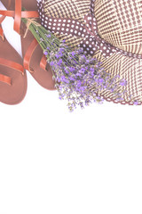 Summer fashion composition. Bouquet of purple lavender, women's summer straw hat and leather sandals isolated on white top view. Flat lay, copy space. Woman accessories from above. Vacation concept.