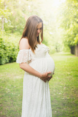 Obraz premium Happy pregnant woman posing over green natural background