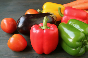 Closeup a red bell pepper with other colorful vegetables on wooden table 