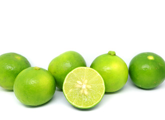 Cut fresh lime with whole fruits rowed up on white background