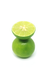 Fresh lime in cross section put over the whole fruit isolated on white background 