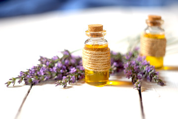 Lavender oil and lavender flowers on white background