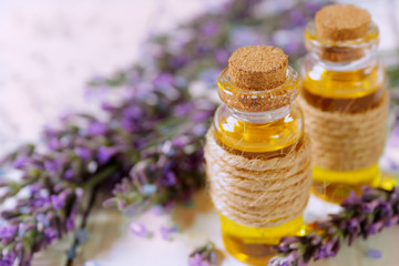 Lavender oil and lavender flowers on white background