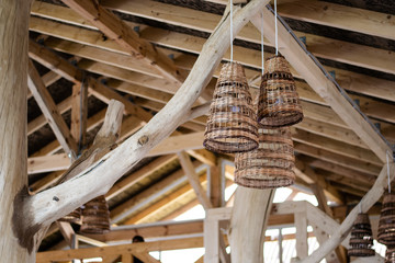 Handcraft lamp with weave pattern hanging from wooden ceiling. Traditional handcraft made from wooden vine widely used for interior decoration and furniture. interior of wood and trees