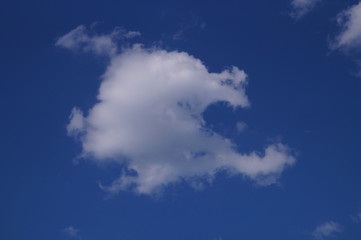 Fototapeta na wymiar In summer, white clouds float across the blue sky.