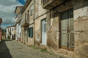 Old houses with cracked plaster wall and wooden door