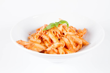Penne with pesto rosso and sun dried tomatoes decorated with basil	