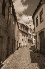 Fototapeta premium Deserted alley and old houses with stone wall