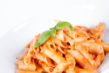 Penne with pesto rosso and sun dried tomatoes decorated with basil	