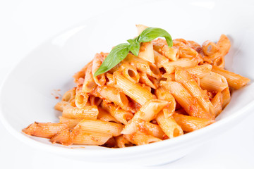 Penne with pesto rosso and sun dried tomatoes decorated with basil	