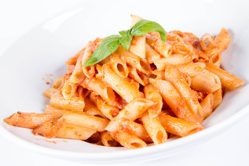 Penne with pesto rosso and sun dried tomatoes decorated with basil	
