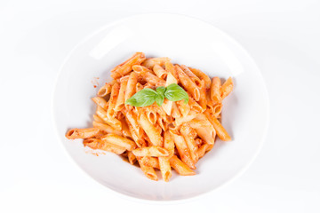 Penne with pesto rosso and sun dried tomatoes decorated with basil	