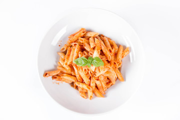 Penne with pesto rosso and sun dried tomatoes decorated with basil	