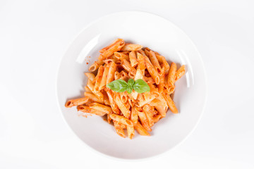 Penne with pesto rosso and sun dried tomatoes decorated with basil	