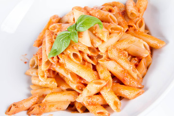 Penne with pesto rosso and sun dried tomatoes decorated with basil	