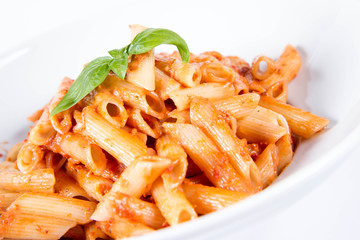 Penne with pesto rosso and sun dried tomatoes decorated with basil	