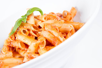 Penne with pesto rosso and sun dried tomatoes decorated with basil	