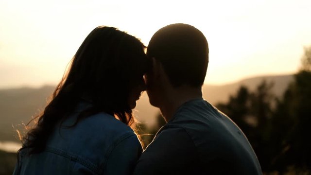 Silhouettes of a young couple in love at sunset.