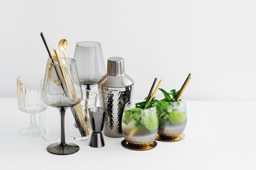 Cocktail with lime, mint and ice and  bar accessories on. Summer drinks.