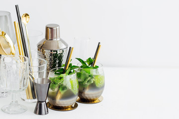 Cocktail with lime, mint and ice and  bar accessories on. Summer drinks.