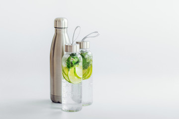 Fresh lime and mint infused water, cocktail, detox drink, lemonade in reusable bottles. Summer...